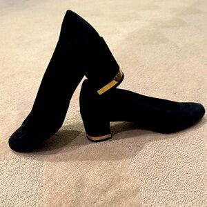 STUART WEITZMAN black suede high vamp pump with gold metal detail on heel.